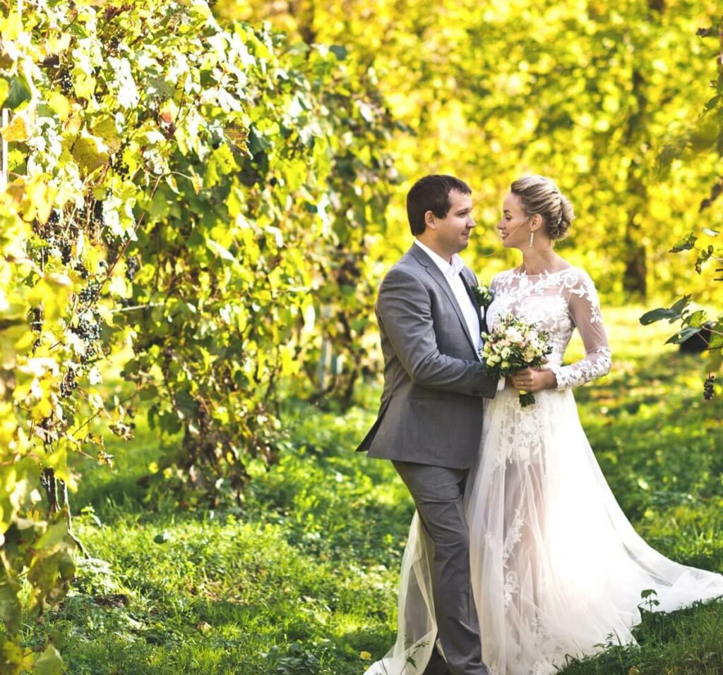 A bride and groom taking photos amongst the vineyard